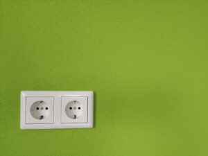 white electric outlet on green wall